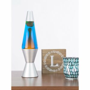 14.5” LAVA® Lamp – Orange/Blue/Silver on shelf with candle and sign