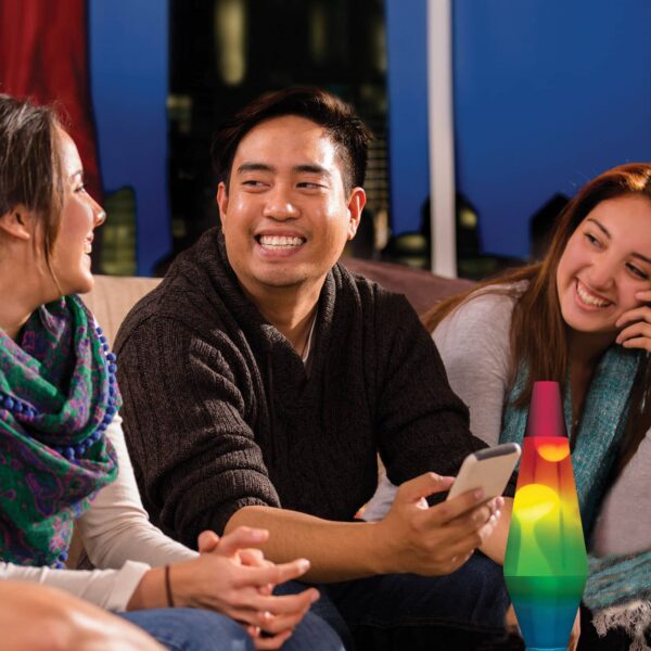 14.5” LAVA® Lamp Rainbow – White/Clear/Tricolor on a coffee table at a party